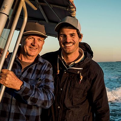 Photo of two men on a fishing boat, smiling to camera after they talked about men's health.