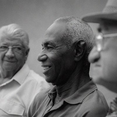 Black and white photo of a smiling man.